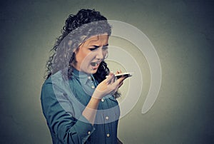 Angry young woman screaming on mobile phone