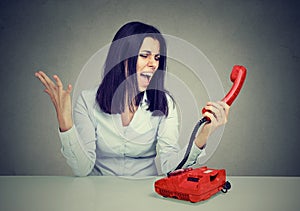 Angry young woman screaming on the phone