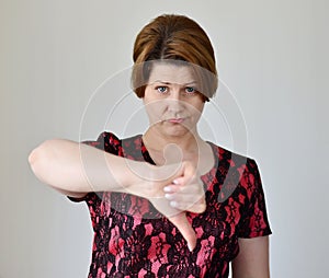 Angry young woman showing thumb down