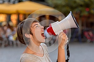 Angry young woman yelling into a megaphone