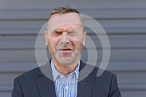 Anguished businessman screwing up is eyes photo