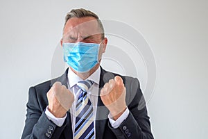Anguished businessman screwing up his eyes and clenching fists photo