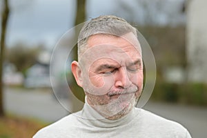 Anguished or troubled senior man outdoors on street photo