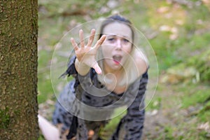 Anguished woman screaming and reaching up to the camera
