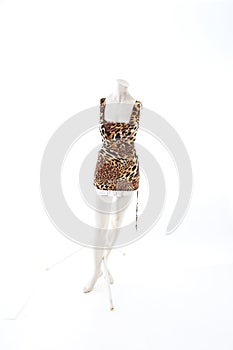 Animal pettern mini dress on mannequin full body shop display. Woman fashion styles, clothes on white studio background.
