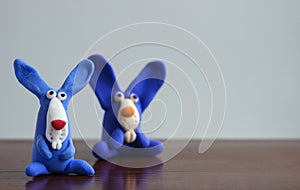 Animals blue rabbits from multi-colored plasticine, which hardens. Children`s creativity. Funny clay toys