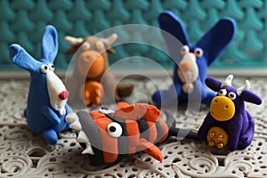 Animals rabbits, cows and fish from multi-colored plasticine, which hardens. Children`s creativity. Funny clay toys