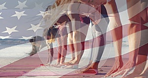 Animation of american flag over diverse women exercising at beach