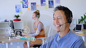 Animation of Asian man smiling with headphones over flying white icons