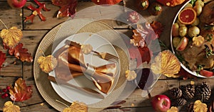 Animation of autumn leaves falling over thanksgiving dinner background