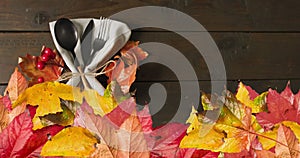 Animation of autumn leaves over thanksgiving dinner place setting background