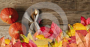 Animation of autumn leaves over thanksgiving dinner place setting background