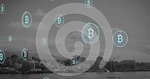 Animation of bitcoin symbols floating against aerial view of cityscape