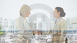 Animation of businesswomen handshake over cityscape