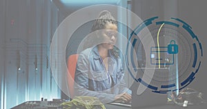 Animation of card, padlock in circle, african american female engineer using laptop at data centre