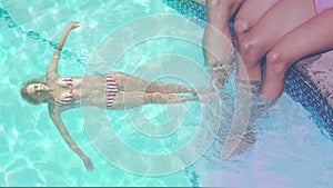 Animation of caucasian woman relaxing in swimming pool over caucasian couple at pool