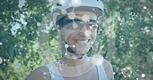 Animation of chemical models over smiling caucasian woman riding bicycle on road