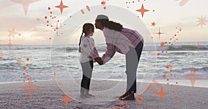 Animation of christmas stars over biracial mother and daughter on beach