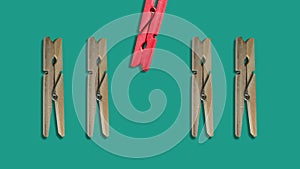 animation of Clothes pegs and one different on color background