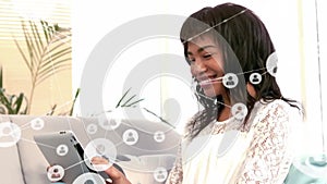 Animation of communication network over smiling african american woman using laptop at home
