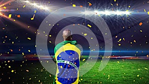 Animation of confetti floating over back of african american man with brazilian flag at stadium