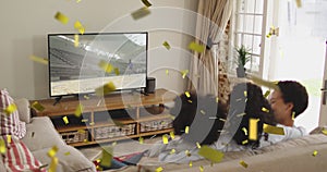 Animation of confetti over happy african american family watching tv