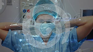 Animation of connections over caucasian female surgeon tying face mask