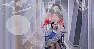 Animation of data processing over biracial businesswoman and female disabled colleague in wheelchair