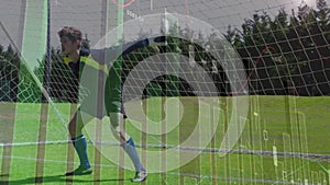 Animation of data processing and statistics over caucasian football goal keeper on pitch