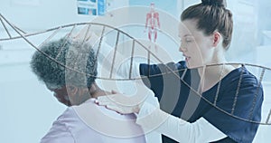 Animation of dna strand over diverse female physiotherapist and senior female patient