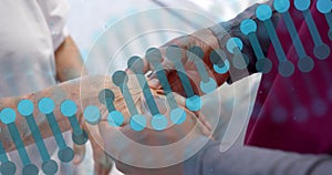 Animation of dna strand rotating over diverse male doctor massaging hand of senior female patient