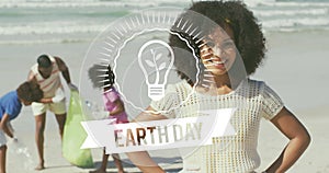 Animation of earth day text over happy african american family picking waste on sunny beach