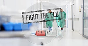 Animation of fight the flue text and syringe over diverse surgeons in hospital