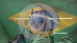 Animation of flag of brazil waving over caucasian woman wearing face mask in city street