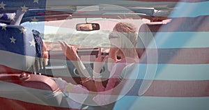 Animation of flag of usa over diverse women in car by beach