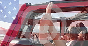 Animation of flag of usa over happy diverse women in car by beach in summer