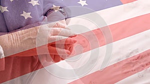 Animation of flag of usa over senior caucasian female patient holding hands
