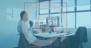 Animation of flash sale text banner over thoughtful frican american man working on a plan at office