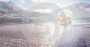 Animation of glowing light over portrait of happy senior woman