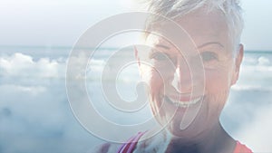 Animation of glowing light over portrait of happy senior woman