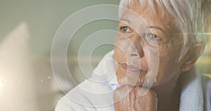 Animation of glowing lights over thoughtful senior woman in background