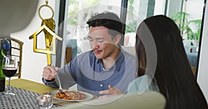 Animation of gold house key and key fob over happy biracial couple eating at home