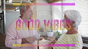 Animation of good vibes in pink over happy caucasian senior couple having coffee talking in kitchen