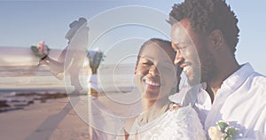 Animation of happy african american couple over dancing couple on beach