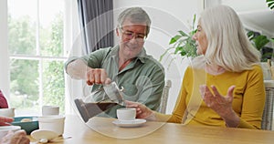 Animation of happy caucasian female and male senior friends drinking coffee at home