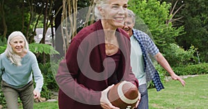 Animation of happy diverse female and male senior friends playing american football in garden