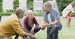 Animation of happy diverse female and male senior friends playing american football in garden