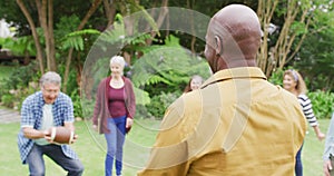 Animation of happy diverse female and male senior friends playing american football in garden