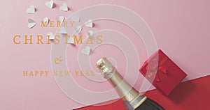 Animation of happy new year text over champagne, hearts and red present