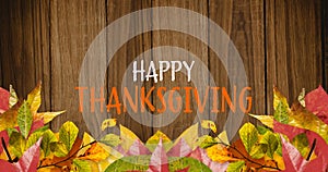 Animation of happy thanksgiving overautumn leaves and wooden background